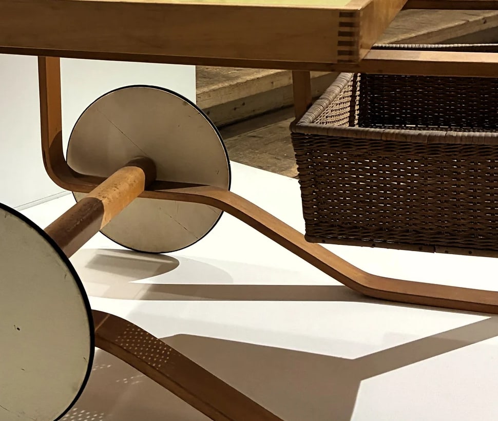 Cropped detail of the Millesgården Aalto trolley, showing the basket beside a large wheel and curved frame; exact model uncertain.