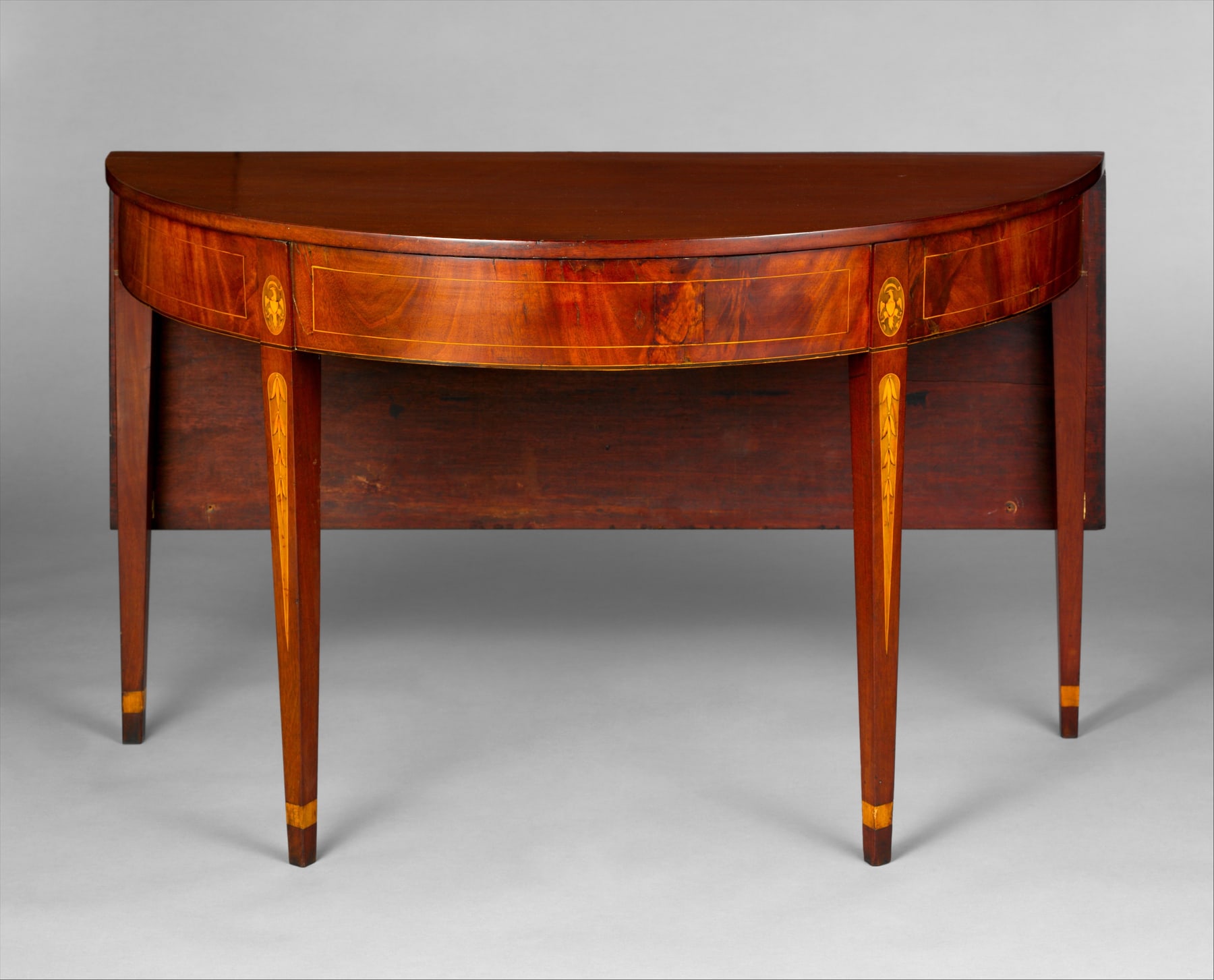 One demilune section of the Baltimore table, with its leaf lowered and its curved front still forming a complete small table.