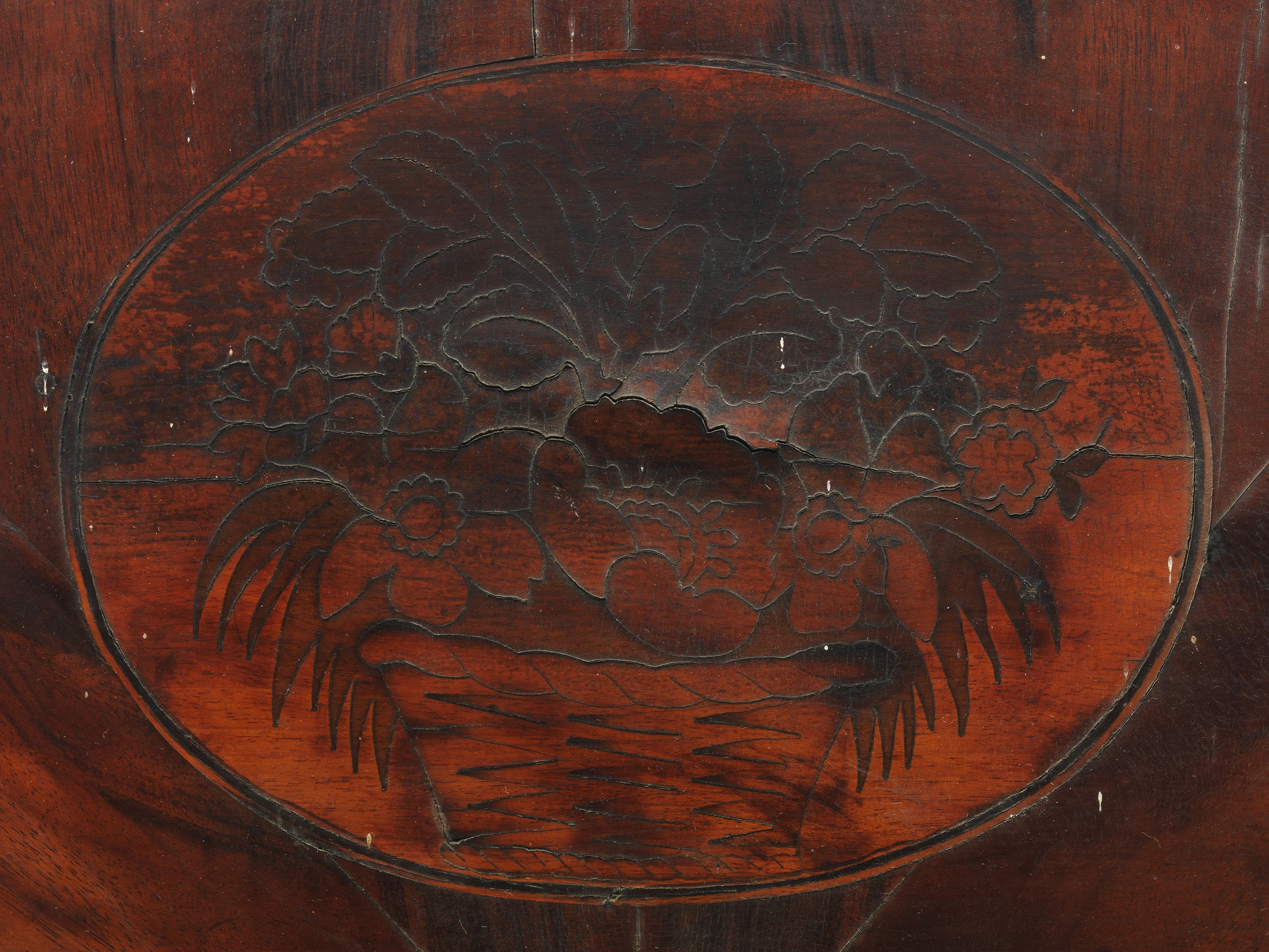 Close view of the chair's half-round crest with radiating mahogany veneer, a central flower-basket inlay and a light-dark border.