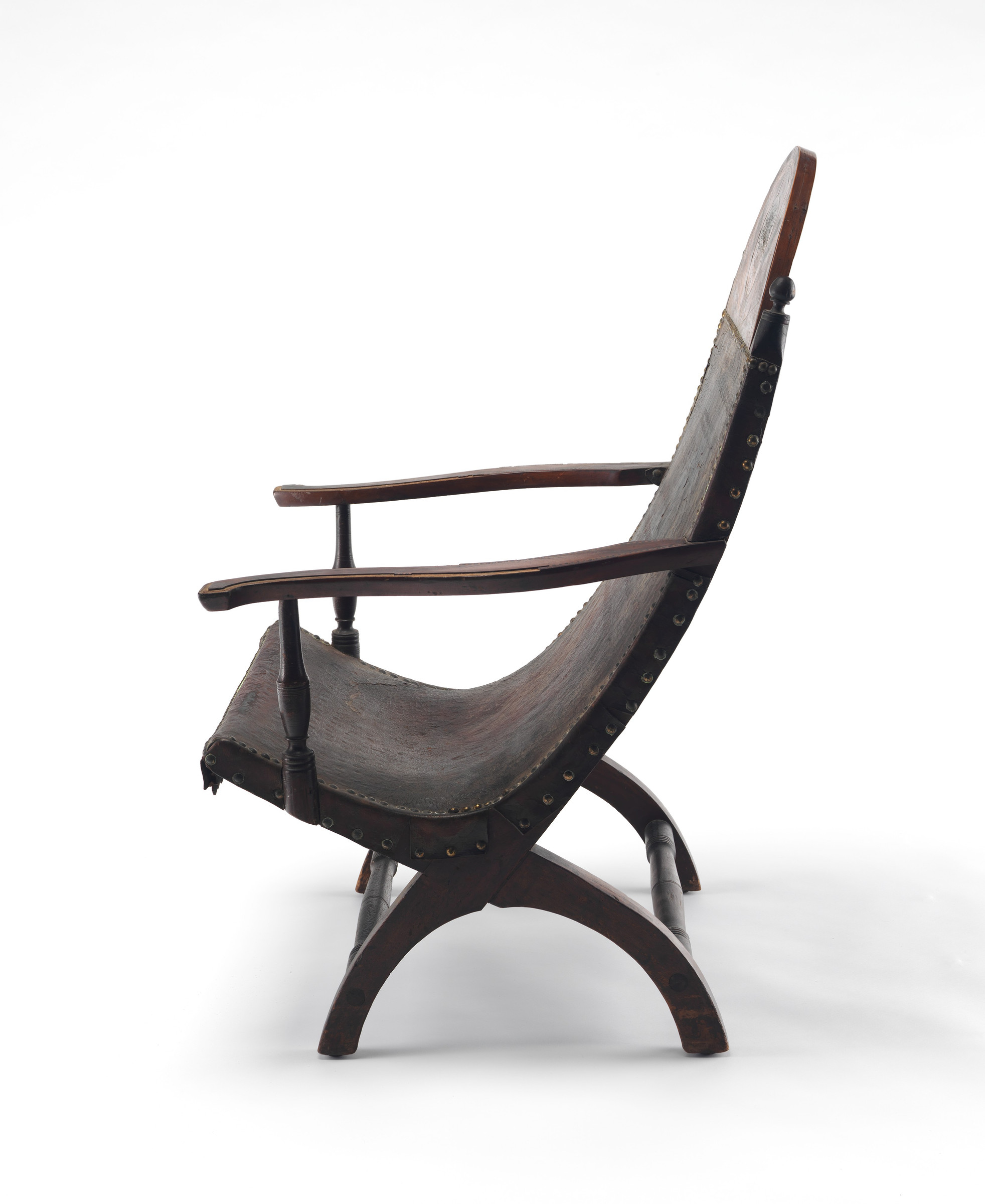 Exact side view of the Campeche chair showing two fixed crossing frame members beneath one deeply curved leather seat and back.
