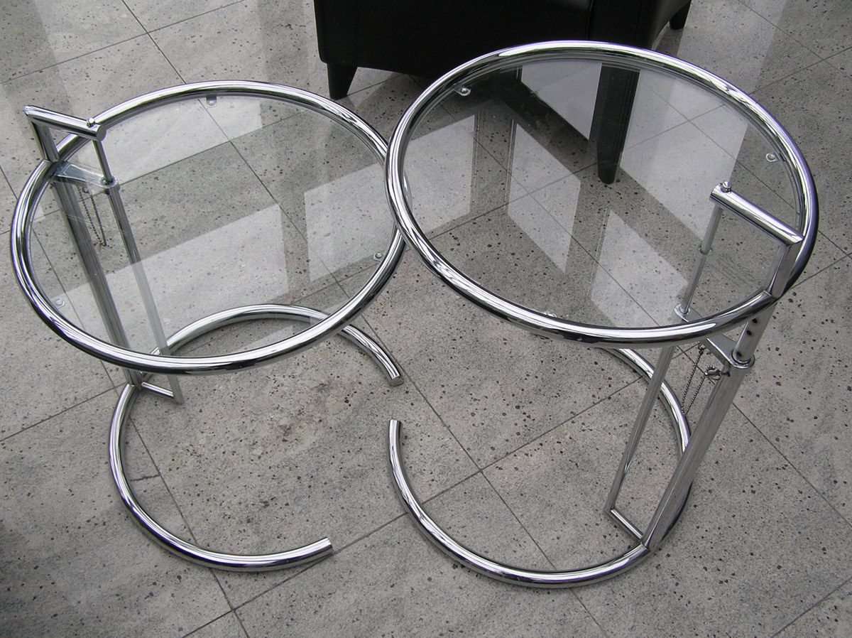 Overhead view of two later glass-top E-1027 tables, clearly showing the gap in each circular base and their exposed adjustment frames.