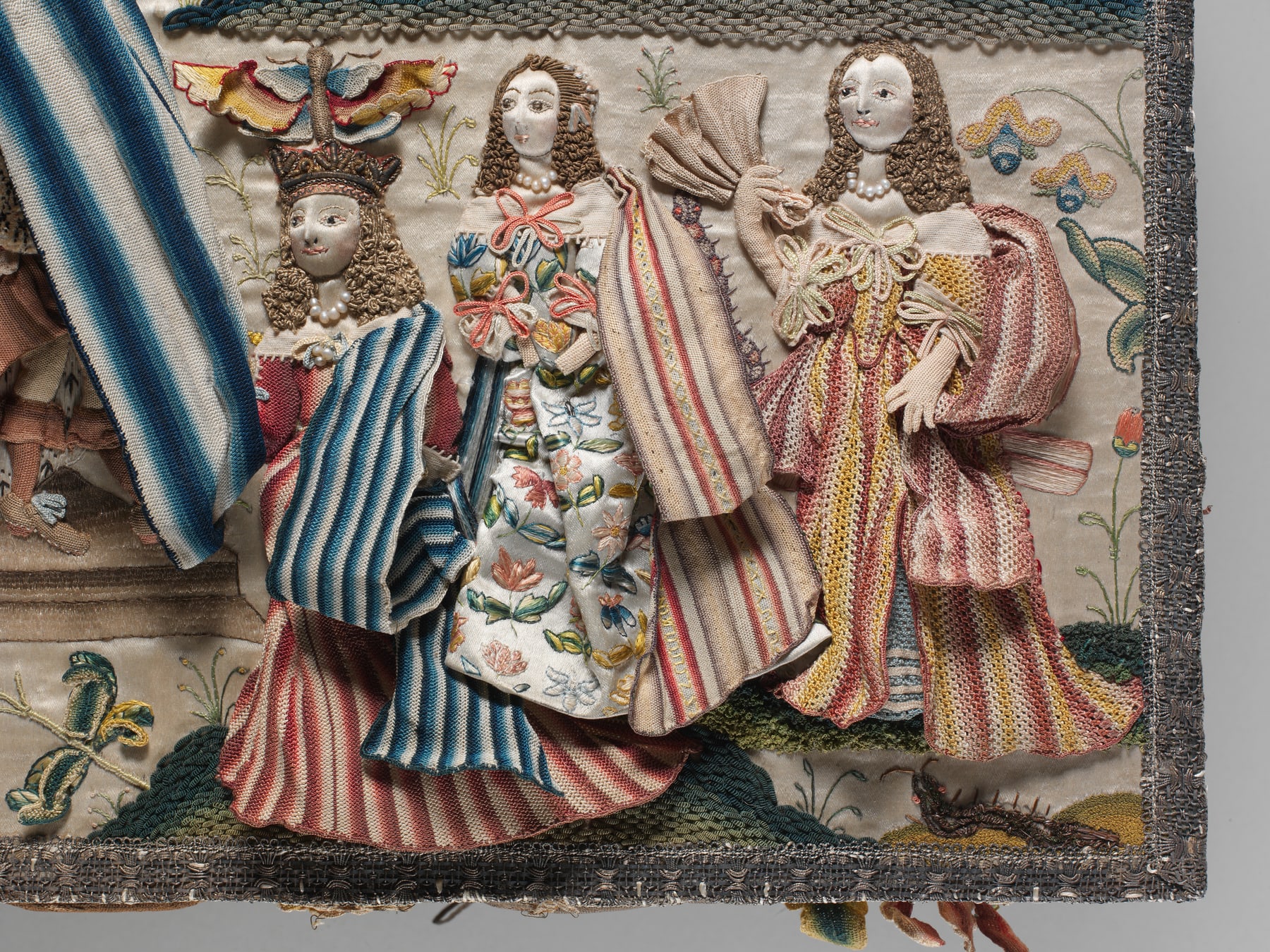 Close view of raised embroidery on the cabinet’s Esther scene; this photograph shows exterior needlework, not the mirrored interior.