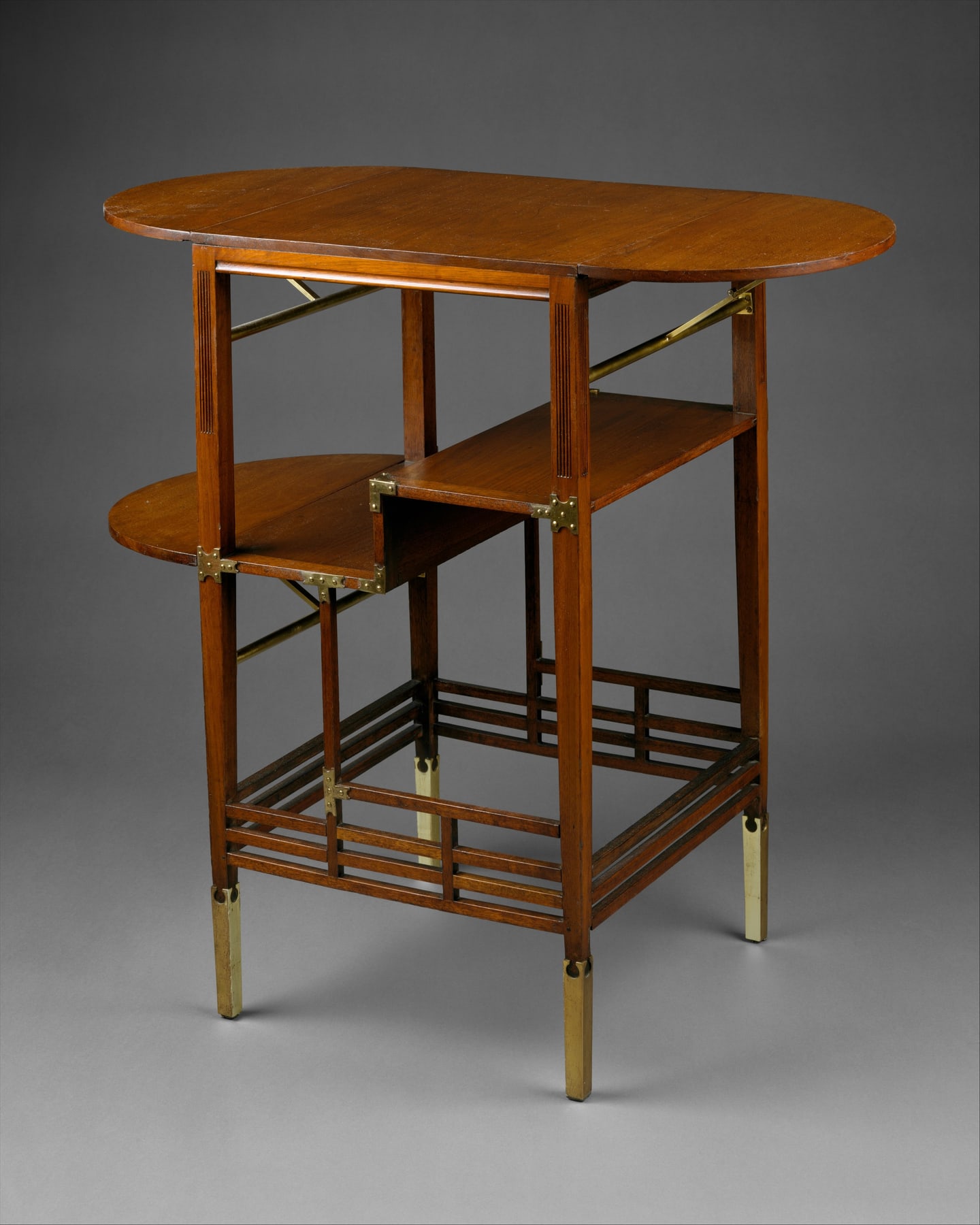 Godwin’s walnut side table with slender posts, offset shelves and small gilt-brass braces.