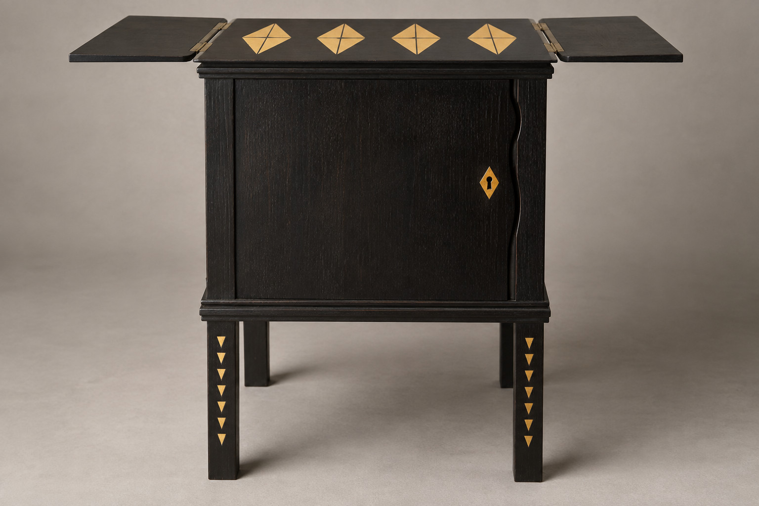 A reconstructed small black cabinet on four straight legs has yellow geometric inlay and two open horizontal top flaps.