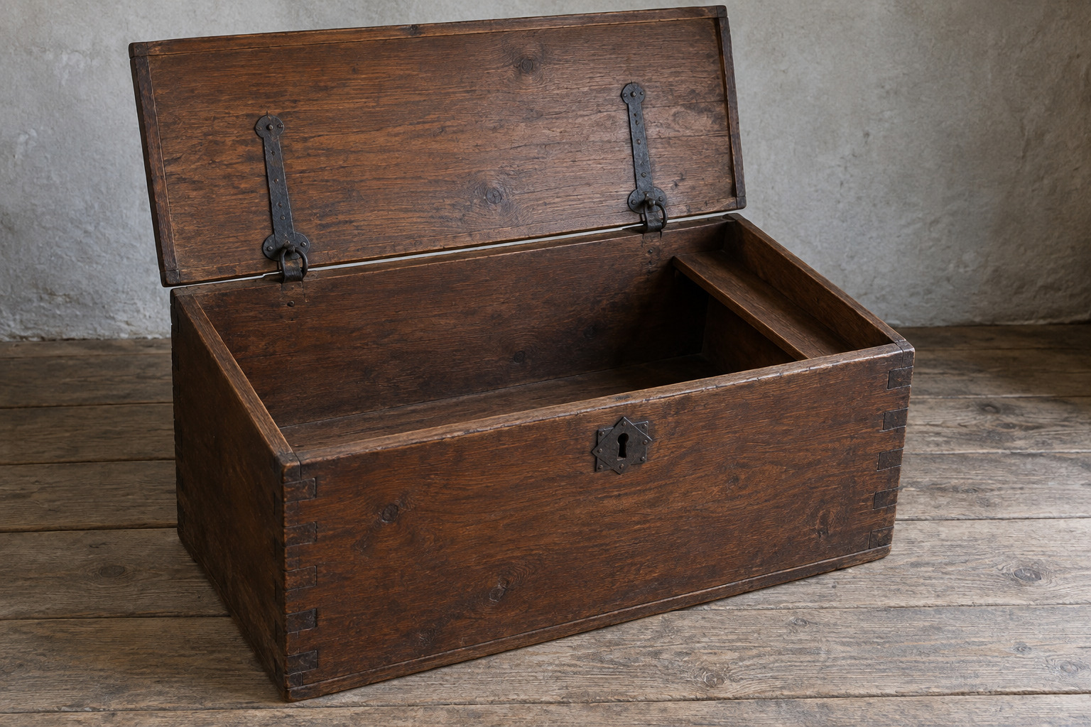An open walnut chest has a plain flat lid, dovetailed corners, iron fittings and a narrow internal shelf.