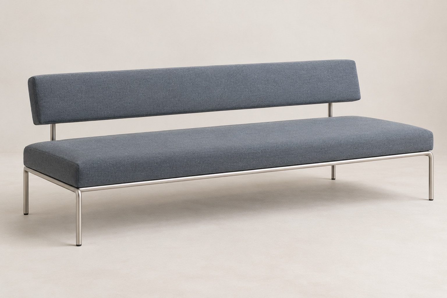 Editorial reconstruction of a blue-grey upholstered sofa with separate cushions on a slender bright metal frame.