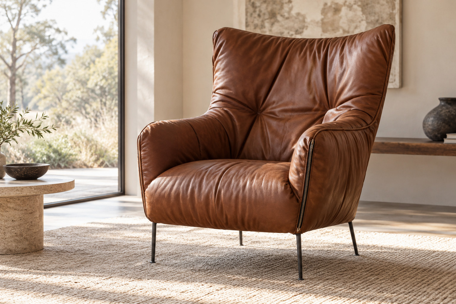 Tall cognac upholstered armchair with a softly gathered outer cover, broad upper back, curved arms and small slender metal legs.