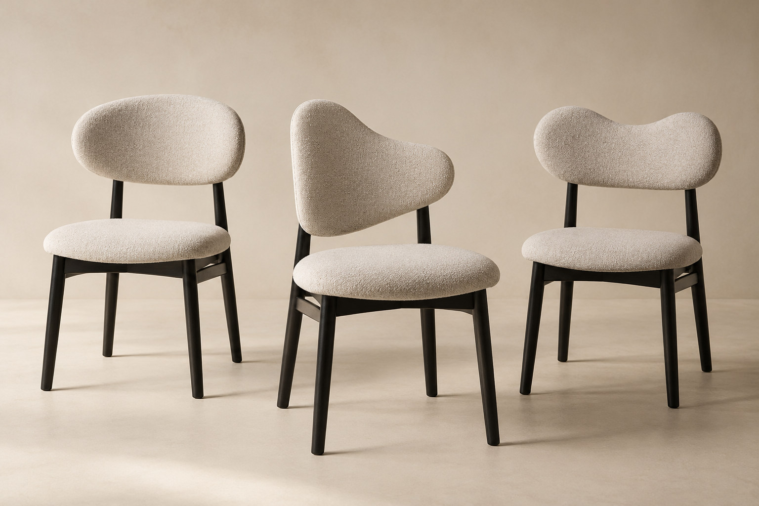 Three upholstered chairs share similar black frames while their irregular back outlines differ.