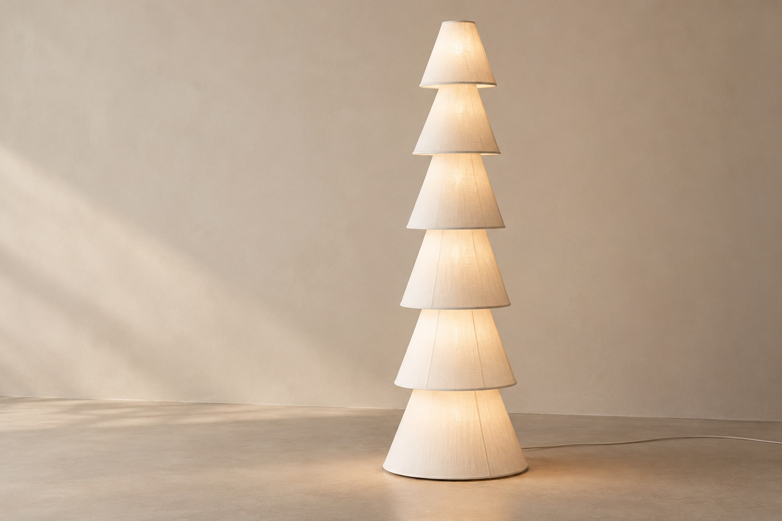 A white lamp repeats conical shade profiles in one vertical column.