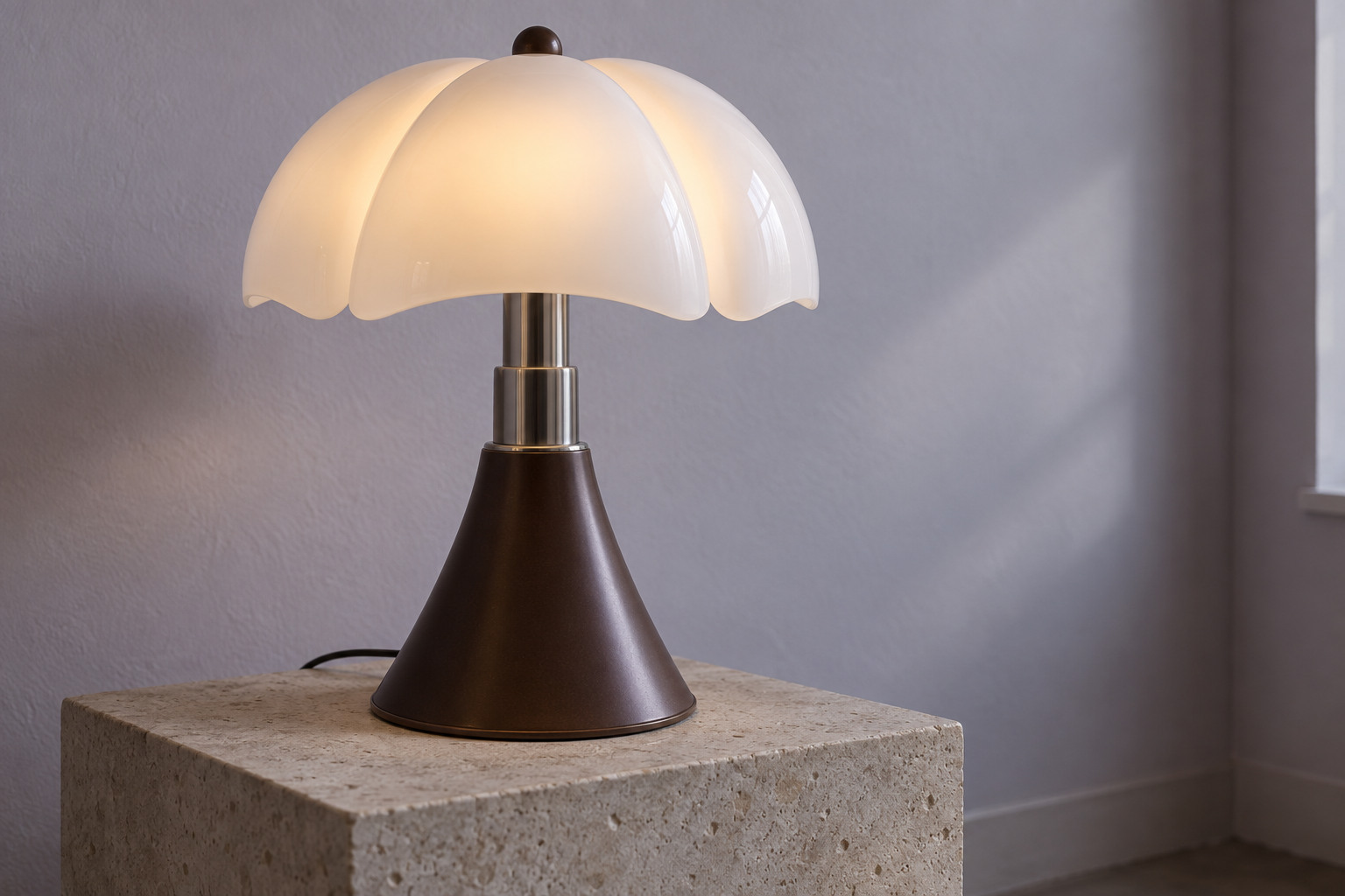 A luminous white lobed shade sits above a telescopic steel neck and a dark flared base on a low plinth.