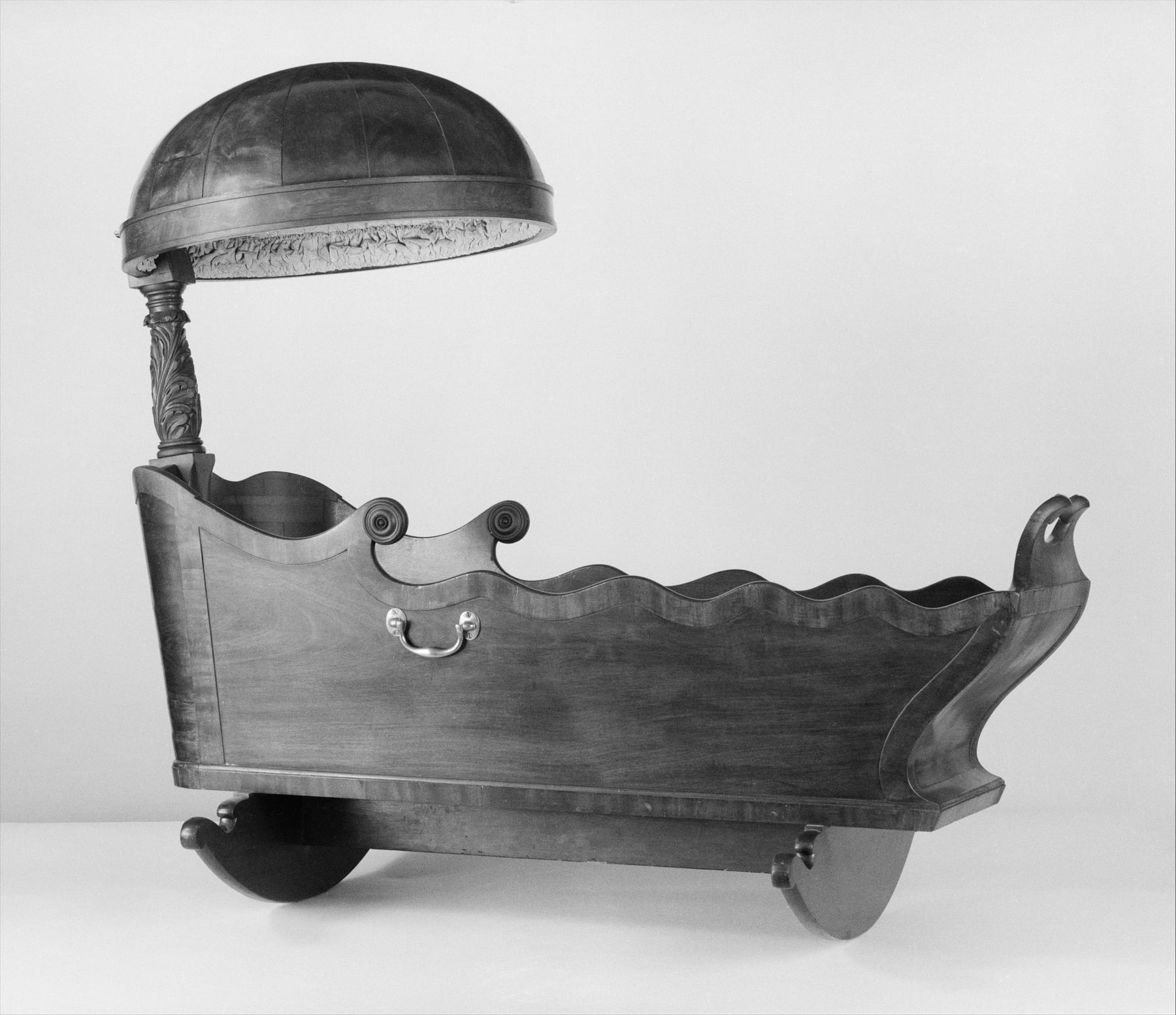 Archival monochrome view of the New York cradle, with a broad hood above a shaped body and curved rockers.
