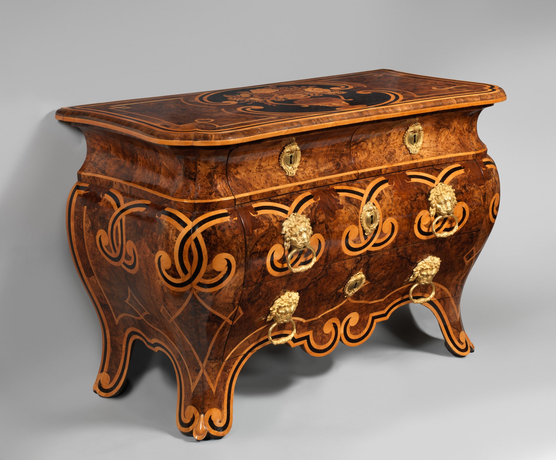 Angled view of Piffetti’s commode showing the rounded end and the veneer continuing around its curved body.
