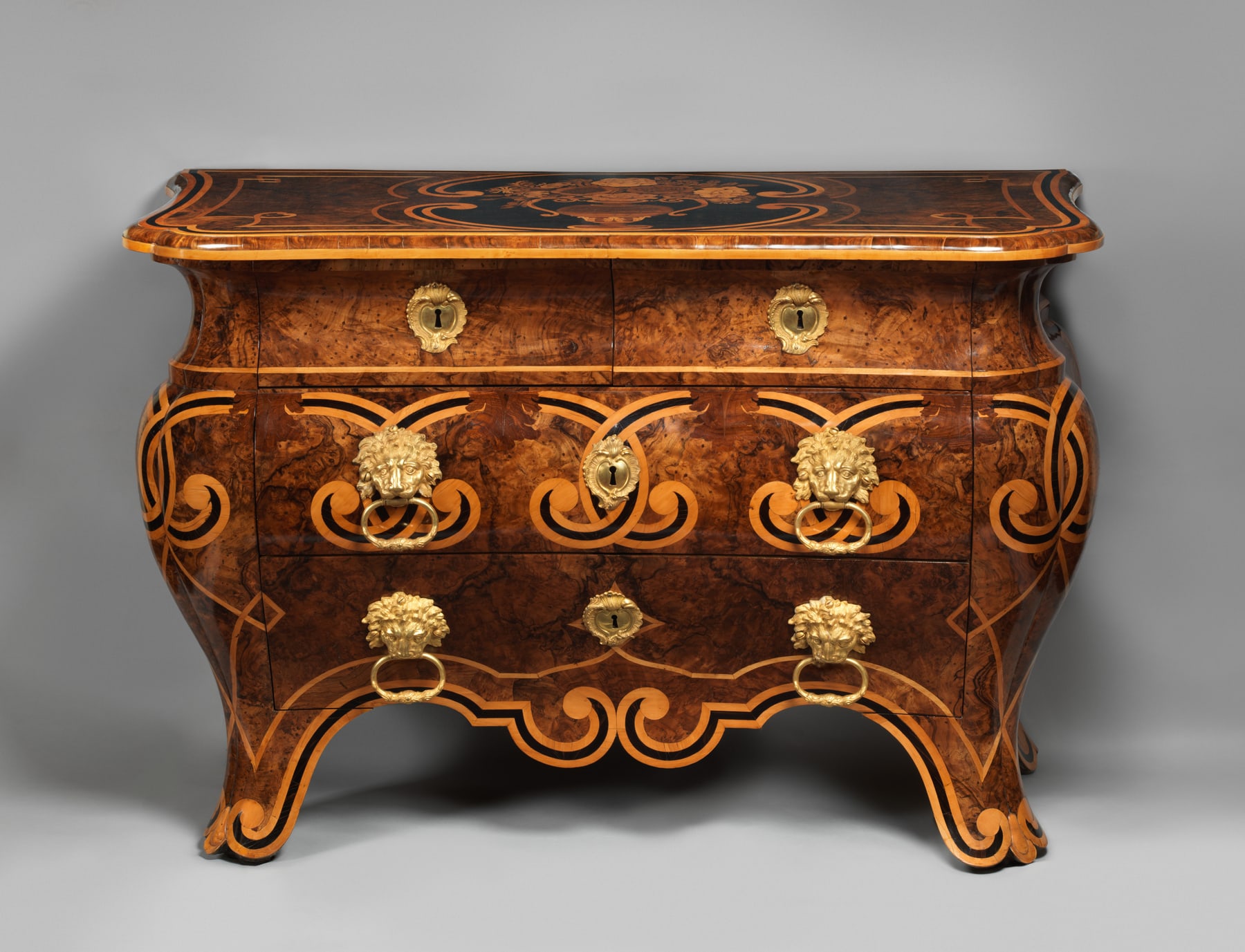 Piffetti’s commode seen from the front, with a curved veneered body, dark dots and gilt-bronze handles.