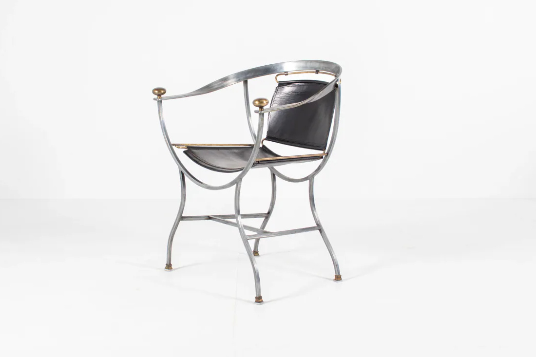 Three-quarter seller photograph of a silver-toned metal Pompei Armchair with black leather seat and back panels and warm-metal terminals.