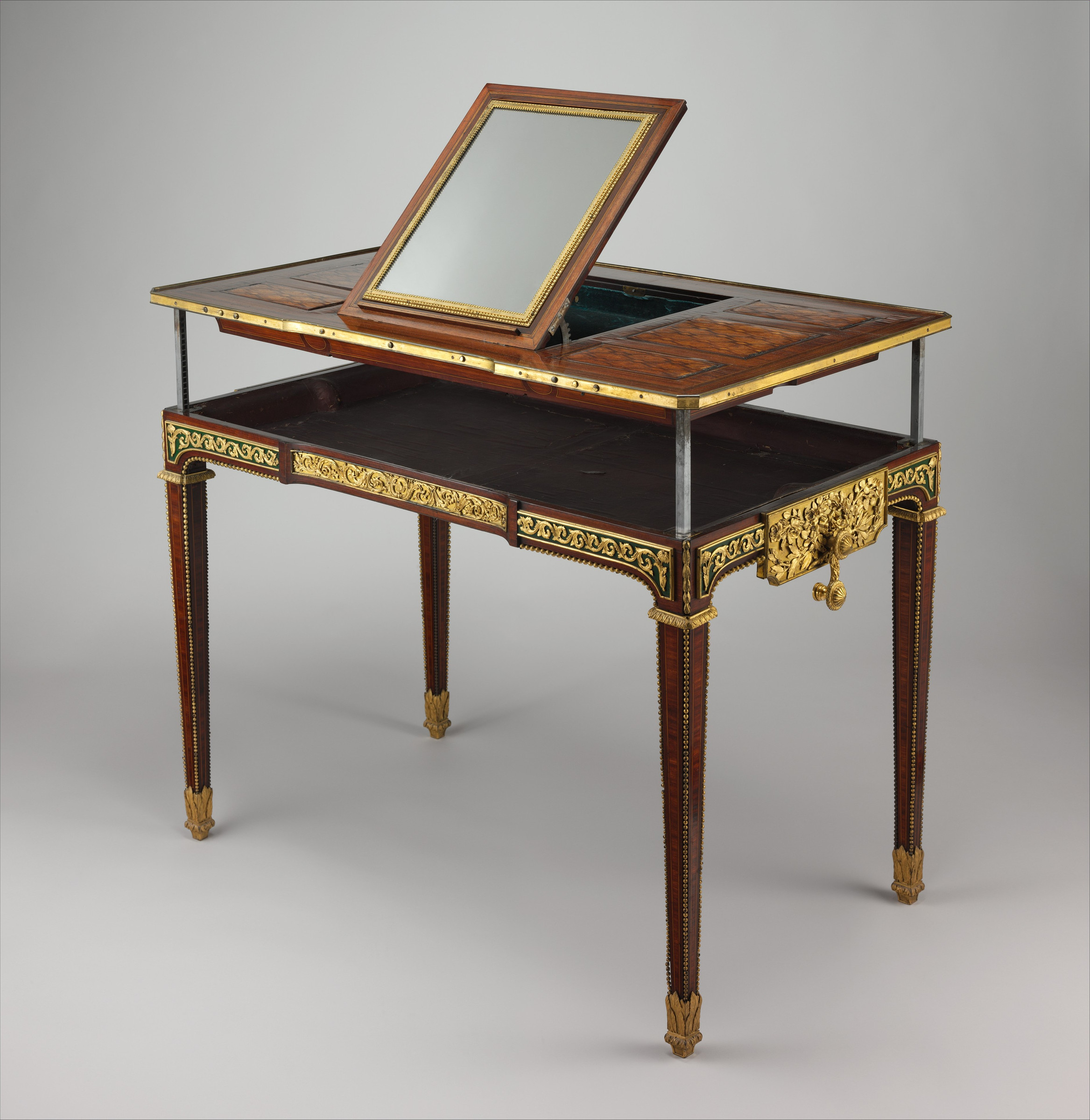 Three-quarter view of the same ornate table with its entire top raised on four metal shafts and the central panel reversed as a mirror.
