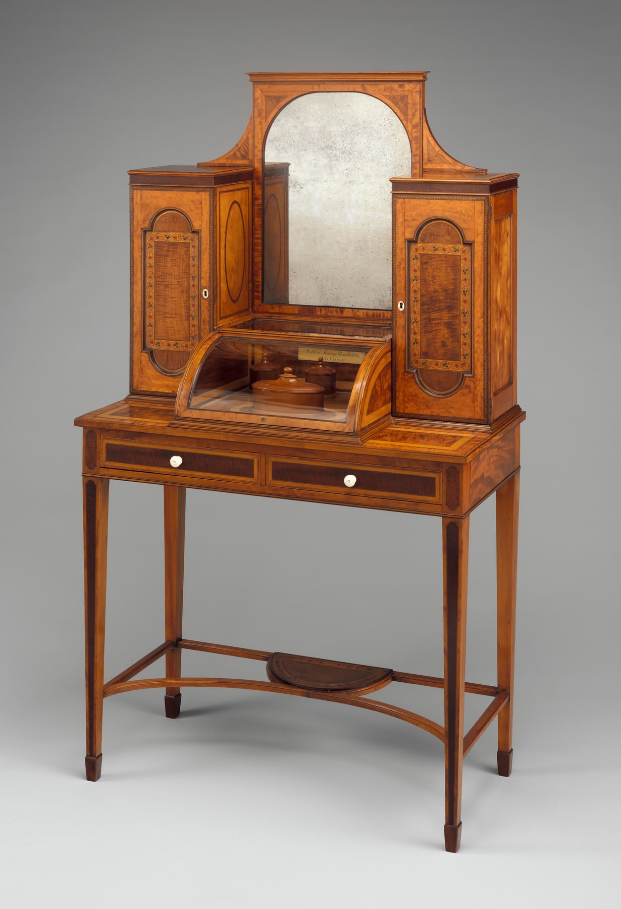 Seddon’s dressing table with a central mirror between tall cupboards and an open knee space below.