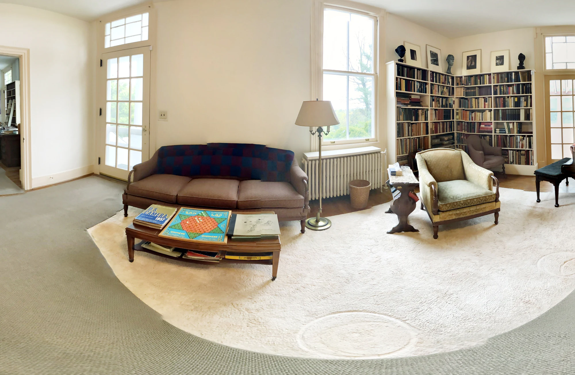 Living room at the Carl Sandburg Home with a low rectangular coffee table in front of a sofa, an armchair to the side and open circulation around the rug.