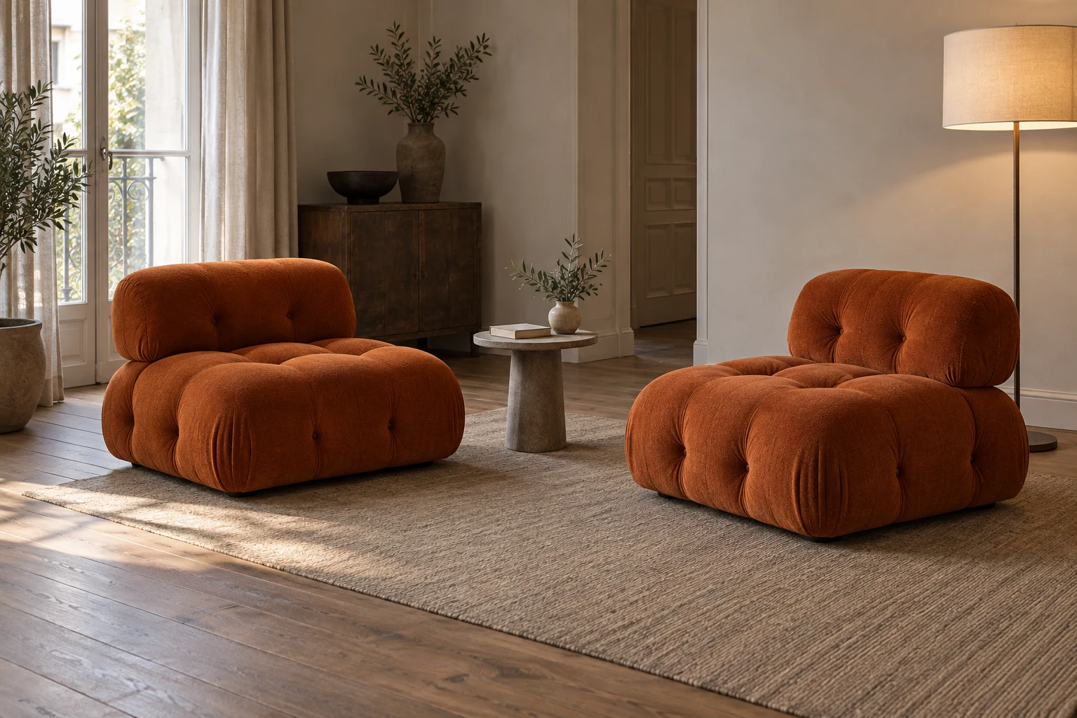 Two rust-coloured, armless tufted seating modules with backs stand separately around a low table, leaving an open route between them.
