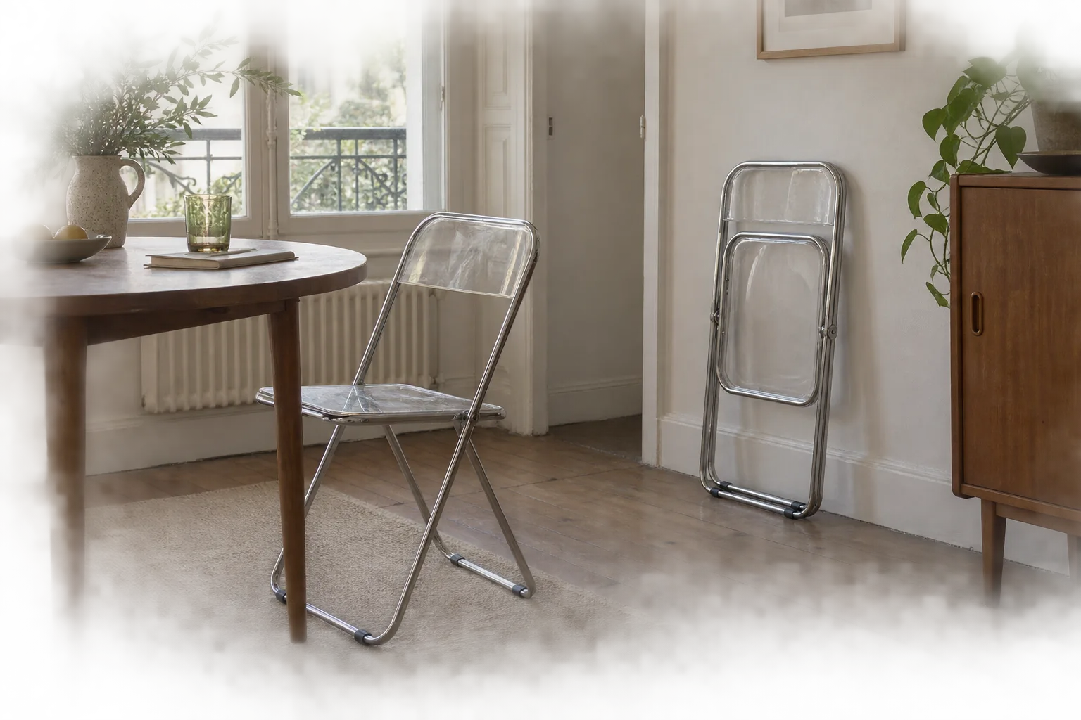 Two clear folding chairs in a dining space, one open and one folded against the wall.