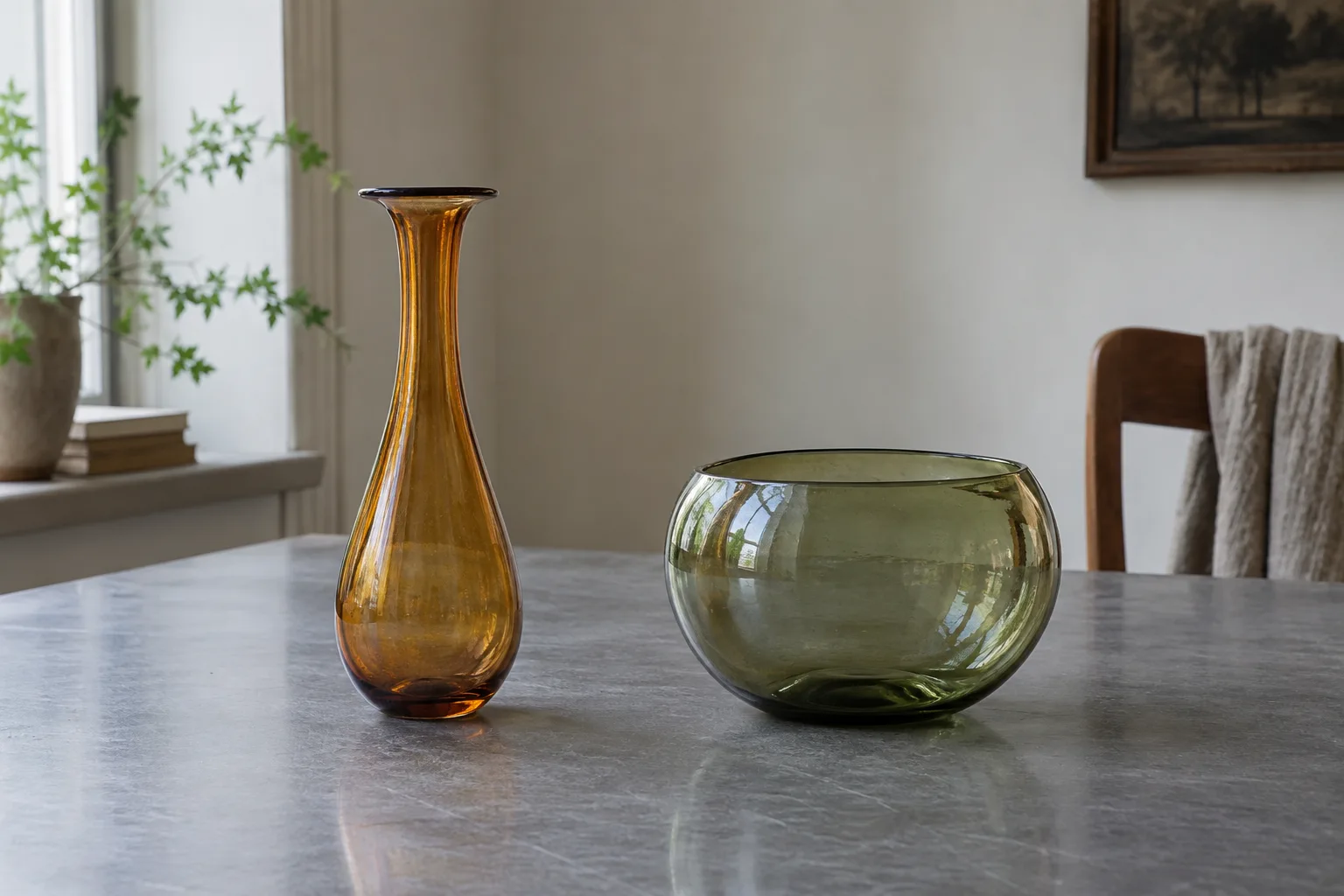 Amber vase and smoky green bowl spaced apart on a plain tabletop.