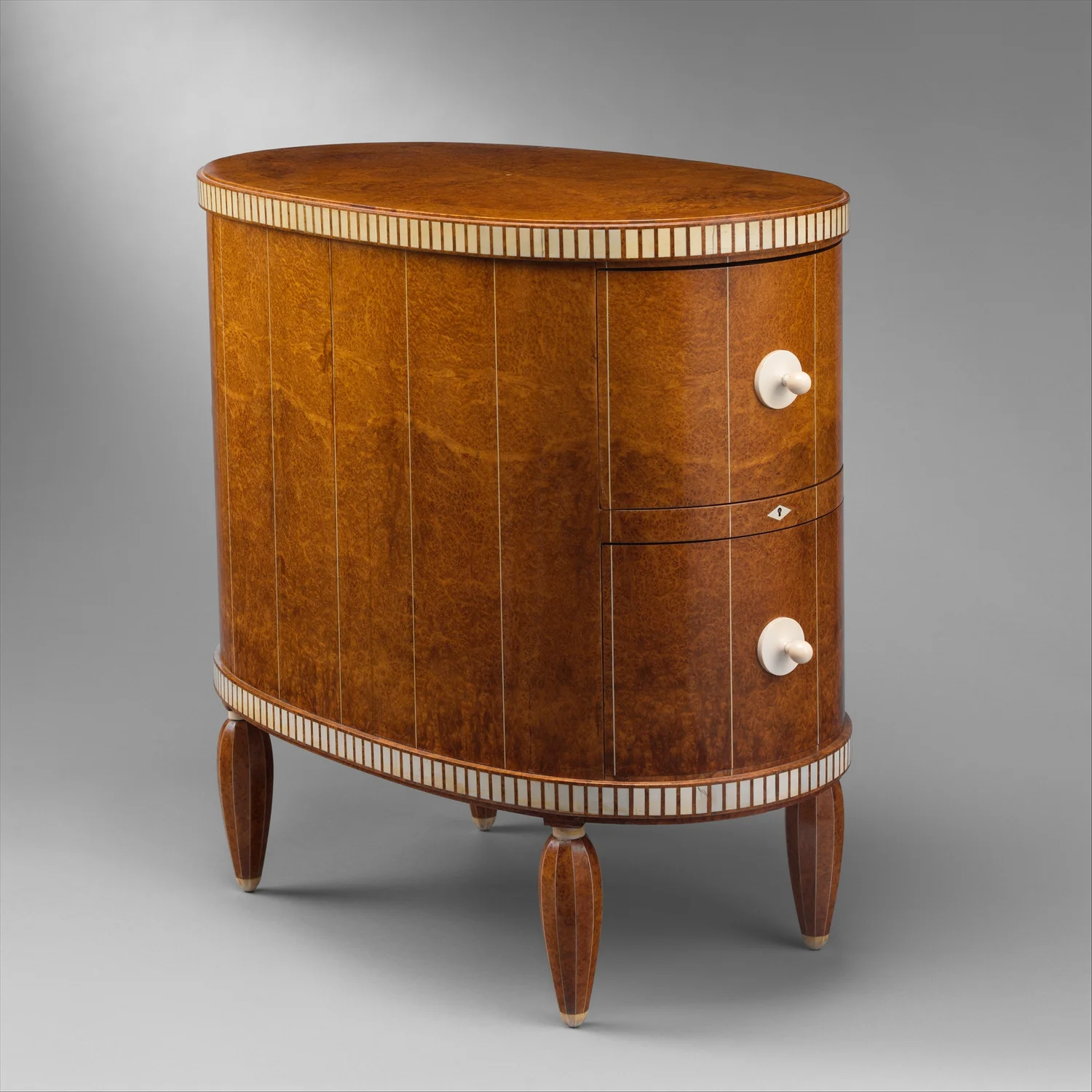Ruhlmann cabinet with a rounded veneered body, pale geometric borders and short tapered legs.