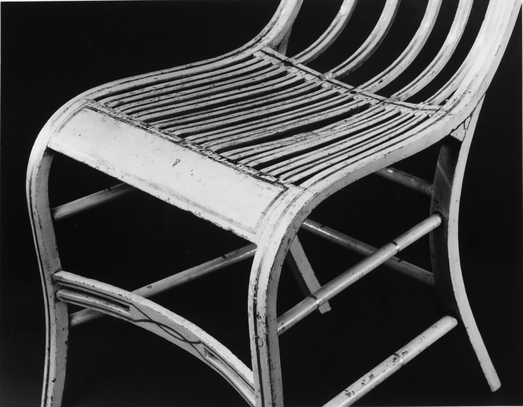 Close view across Gragg's chair seat showing many narrow curved slats fitted between the front rail and the transition into the bowed back.