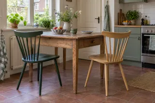 Green and natural timber fan-back chairs at a compact kitchen table.