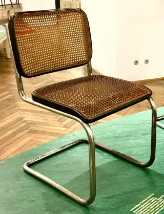 An early B32 cantilever chair with cane panels in dark wooden frames, displayed at MAK Vienna.