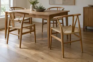 Four wooden Y-back dining chairs with woven seats surround a rectangular table; two are pulled out to show the curved backs and arms.