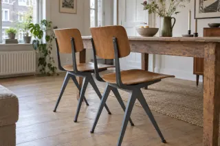 Older-style wood and metal dining chairs arranged at a timber table.