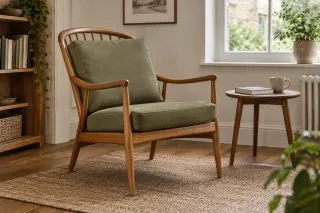 Open wooden spindle-back easy chair with olive seat and back cushions in a reading corner.