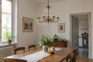 A small brass and glass-drop chandelier above a wooden dining table.