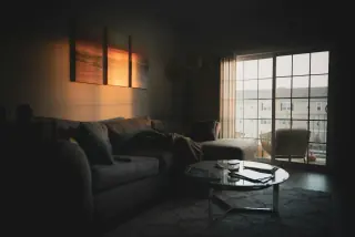 Grey L-shaped sectional sofa beside a window, with a chaise extending towards a coffee table.