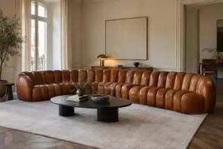 A low brown modular sofa made from narrow repeated elements curves around a living-room rug.