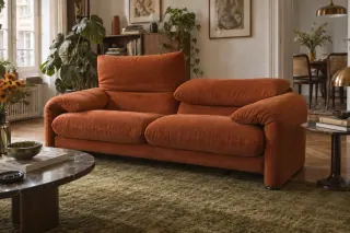 An orange upholstered sofa has one back cushion raised and the other in a lower position.