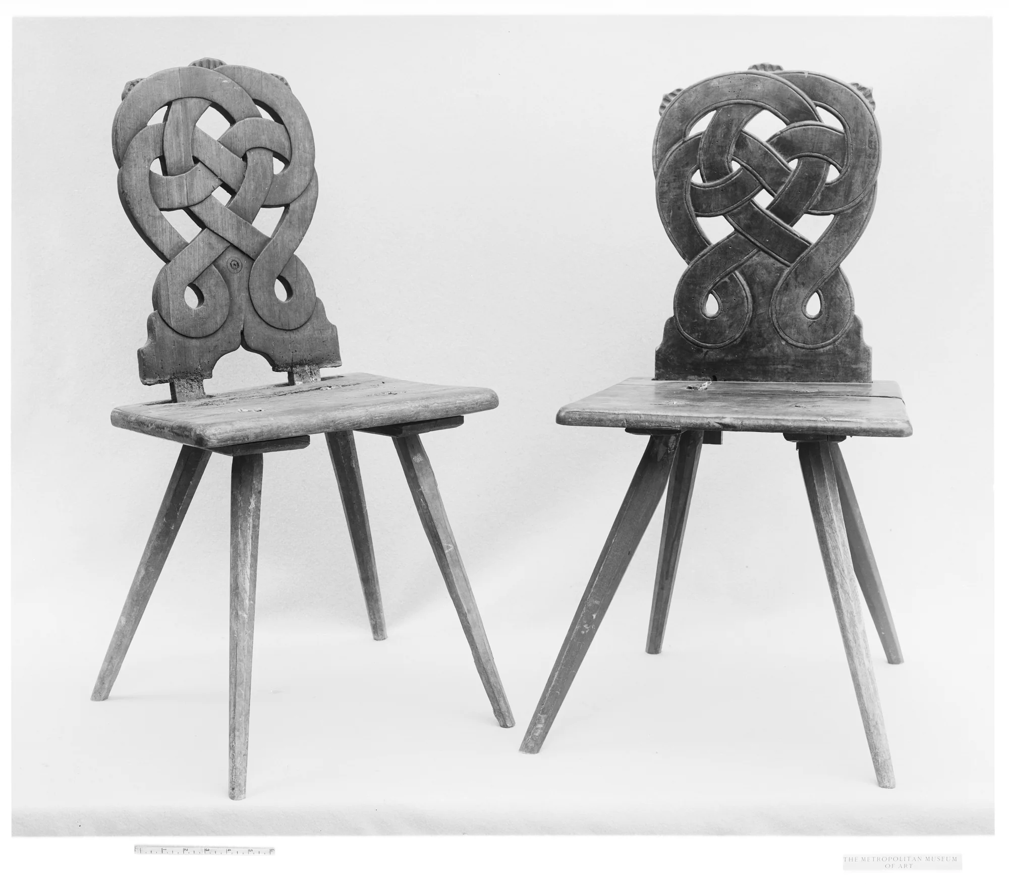 Two eighteenth-century wooden chairs photographed together, with visibly different surface tone and carved back details.